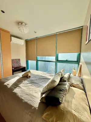 a bedroom with a large bed with pillows on it at Cozy 1br unit in Uptown BGC in Manila