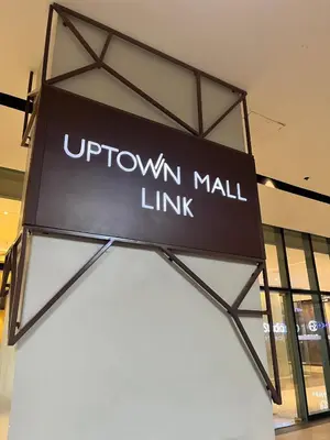 a sign for a brown mall link in a store at Cozy 1br unit in Uptown BGC in Manila