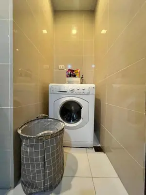 a laundry room with a washing machine and a trash can at Cozy 1br unit in Uptown BGC in Manila