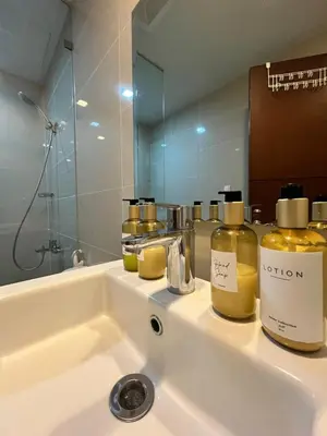 a bathroom sink with two bottles of perfume on it at Cozy 1br unit in Uptown BGC in Manila