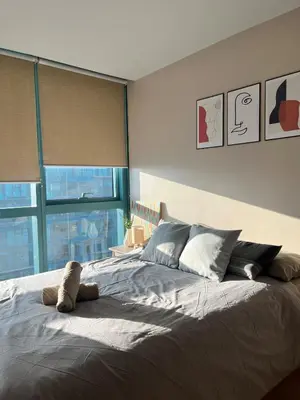 a bedroom with a large bed with a large window at Cozy 1br unit in Uptown BGC in Manila