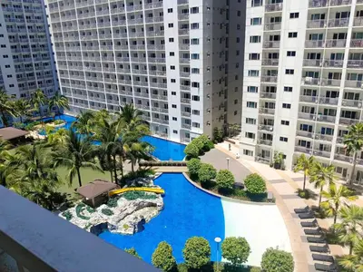 an aerial view of a resort swimming pool with buildings at Staycation Zone in Manila