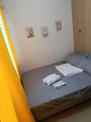 a bed with two towels and napkins on it at Staycation Zone in Manila
