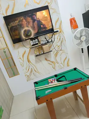 a tv and a pool table in a room at Staycation Zone in Manila