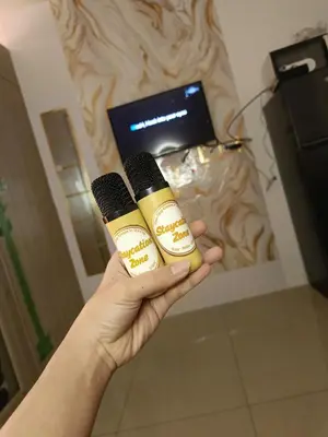 a person holding two microphones in a room at Staycation Zone in Manila