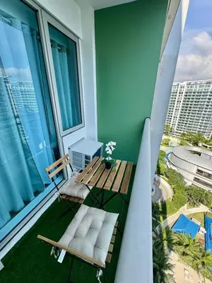 a balcony with a bench and a table and chairs at SM Bicutan Escape Staycation in Manila