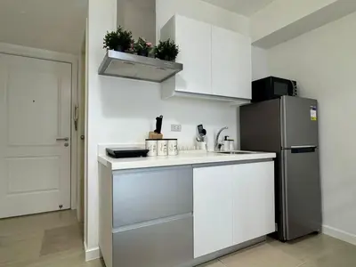 a kitchen with white cabinets and a refrigerator at SM Bicutan Escape Staycation in Manila