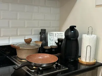 a kitchen counter with a pan on a stove at The Lay-by Fame MRT Megamall Greenfield Greenhills in Manila