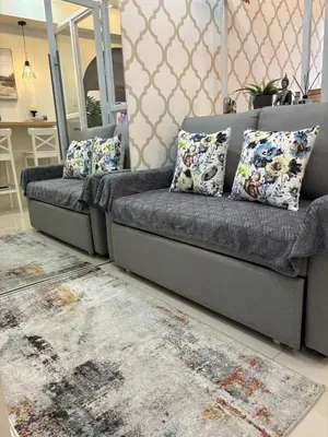 a grey couch with pillows in a living room at The Lay-by Fame MRT Megamall Greenfield Greenhills in Manila