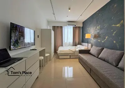 a living room with a couch and a bedroom at Tom's Place in Manila