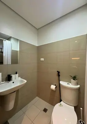 a bathroom with a toilet and a sink at Tom's Place in Manila