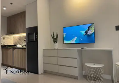 a living room with a tv on a white wall at Tom's Place in Manila