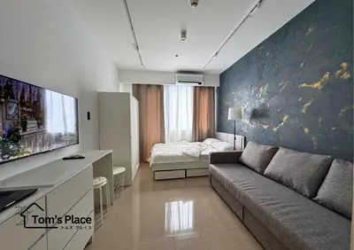 a living room with a couch and a bedroom at Tom's Place in Manila