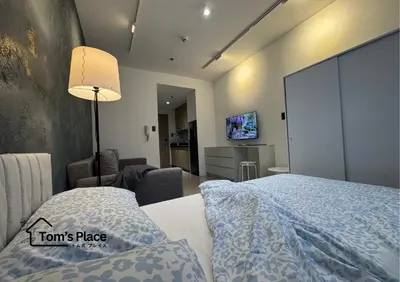 a hotel room with a bed and a tv at Tom's Place in Manila