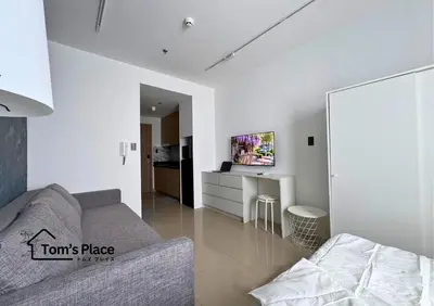 a white living room with a couch and a table at Tom's Place in Manila