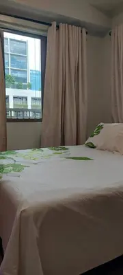 a bedroom with a white bed with a window at Jovy Place At Shore Residences&Sea Residences near Moa in Manila