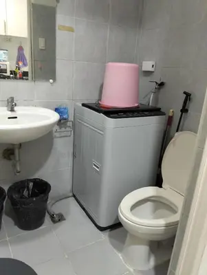 a bathroom with a toilet and a sink with a pink container at Jovy Place At Shore Residences&Sea Residences near Moa in Manila