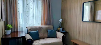 a room with a chair and a table and a window at Jovy Place At Shore Residences&Sea Residences near Moa in Manila