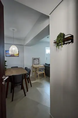 a living room with a table and a dining room at I-LAND Residences Sucat near NAIA w Wifi free parking in Manila