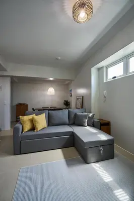 a living room with a blue couch with yellow pillows at I-LAND Residences Sucat near NAIA w Wifi free parking in Manila