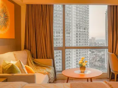 a hotel room with a bed and a large window at The Hotel Residences at Acqua Tower in Manila