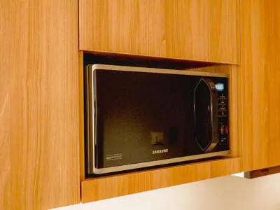 a microwave in a wooden cabinet in a kitchen at The Hotel Residences at Acqua Tower in Manila
