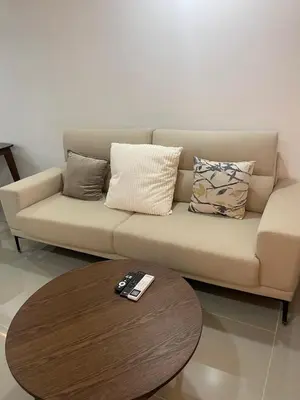 a couch with pillows and a coffee table in a room at Makati City Antel Spa Residences 9B in Manila