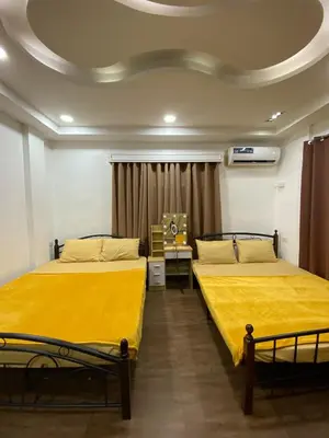 two beds in a room with yellow sheets at Peaceful Port Away From Home in Manila