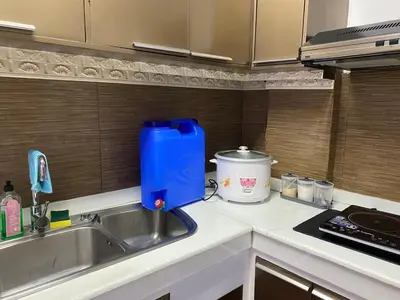 a kitchen sink with a blue container on the counter at Peaceful Port Away From Home in Manila