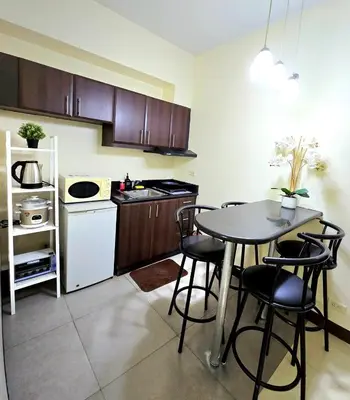 a kitchen with a table and chairs in a room at Studio unit near BGC and Makati in Manila