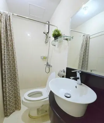 a bathroom with a white toilet and a sink at Studio unit near BGC and Makati in Manila