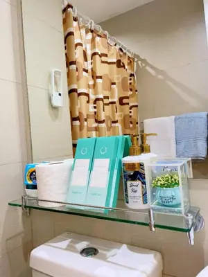a glass shelf above a toilet in a bathroom at Azure Urban Resorts by Rhome in Manila