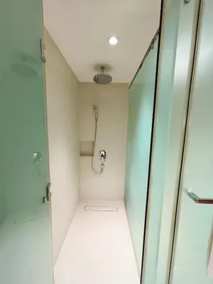a bathroom with a shower and a glass door at The Hotel Residences at Acqua in Manila
