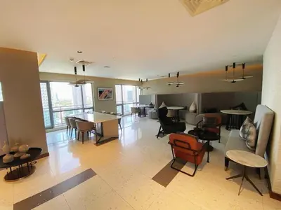a living room with chairs and tables in a room at The Hotel Residences at Acqua in Manila