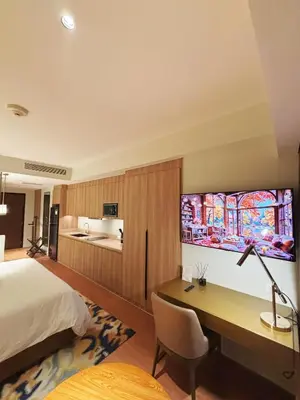 a hotel room with a desk and a bed at The Hotel Residences at Acqua in Manila