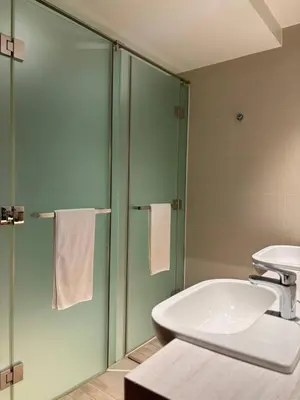 a bathroom with a sink and a toilet and a shower at Hotel Residences At Acqua in Manila