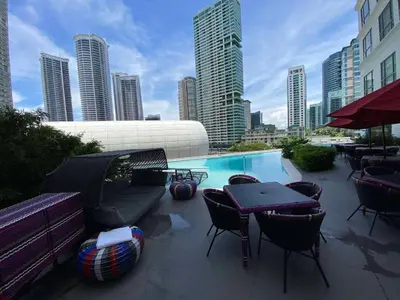 a patio with chairs and a pool in a city at Hotel Residences At Acqua in Manila