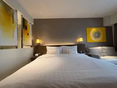 a bedroom with a large white bed with two pillows at The Hotel Residences at Acqua in Manila