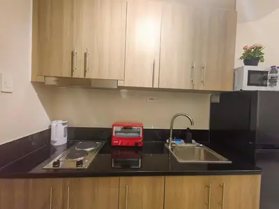 a kitchen with a sink and a red appliance on a counter at 1BR Condotel with Balcony at FAME Residences #FM37-1 in Manila