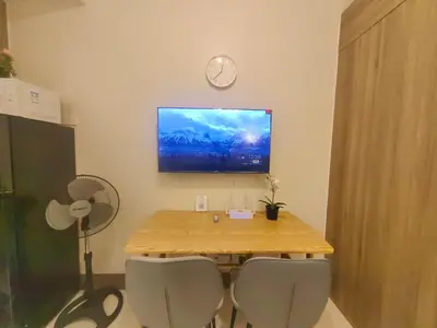 a dining room table with two chairs and a tv on the wall at 1BR Condotel with Balcony at FAME Residences #FM37-1 in Manila