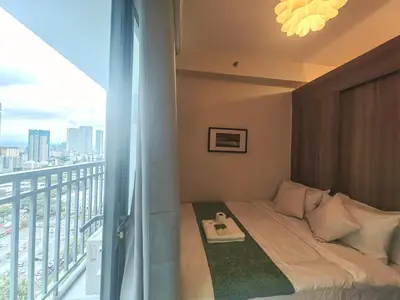 a room with a bed and a balcony with a view at 1BR Condotel with Balcony at FAME Residences #FM37-1 in Manila