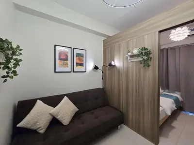 a living room with a couch and a bed at 1BR Condotel with Balcony at FAME Residences #FM38-1 in Manila