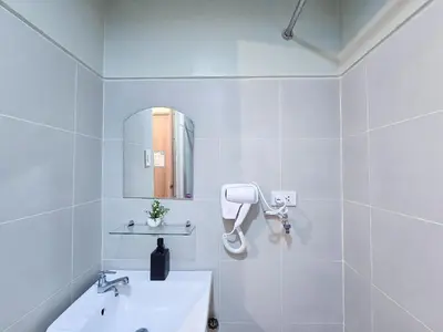 a white bathroom with a sink and a mirror at 1BR Condotel with Balcony at FAME Residences #FM39-1 in Manila