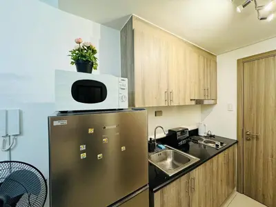 a kitchen with a stainless steel refrigerator with a microwave at 1BR Condotel with Balcony at FAME Residences #FM42-1 in Manila