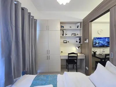 a bedroom with a bed and a desk and a table at 1BR Condotel with Balcony at FAME Residences #FM43-1 in Manila