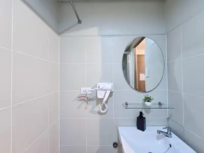 a white bathroom with a sink and a mirror at 1BR Condotel with Balcony at FAME Residences #FM43-1 in Manila