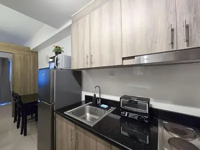 a kitchen with a sink and a stainless steel refrigerator at 1BR Condotel with Balcony at FAME Residences #FM43-1 in Manila