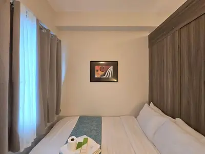 a bedroom with a bed and a picture on the wall at 1BR Condotel with Balcony at FAME Residences #FM46-1 in Manila