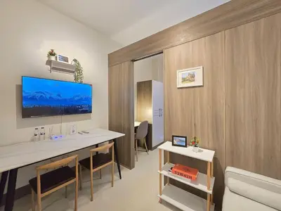 a room with a desk and a tv on a wall at 1BR Condotel with Balcony at FAME Residences #FM46-1 in Manila