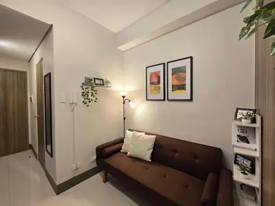 a living room with a couch and a lamp at 1BR Condotel with Balcony at FAME Residences #FM50-1 in Manila